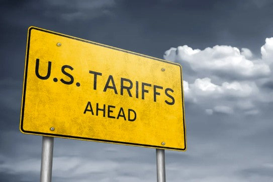 Warning sign reading 'U.S. Tariffs Ahead' with stormy clouds in the background, symbolizing economic impact on Canadian maple syrup exports due to new trade tariffs